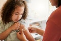 Niña con surita después de ser vacunada